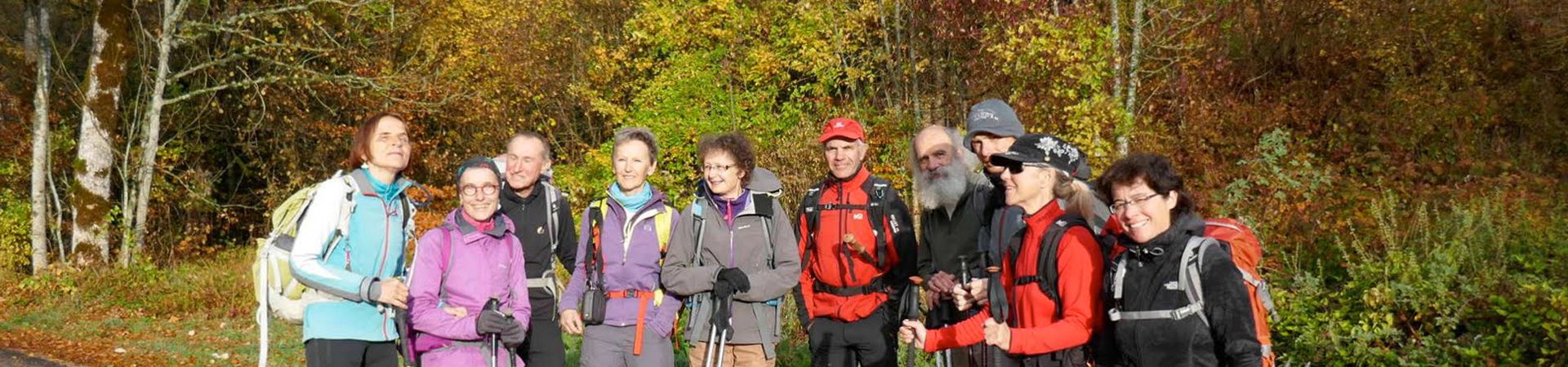 Randonneurs souriants avec des arbres aux couleurs d'automne en arrière-plan