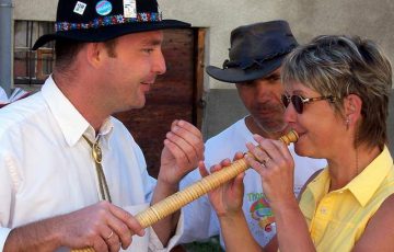 Une randonneuse essaie de jouer du cor des Alpes